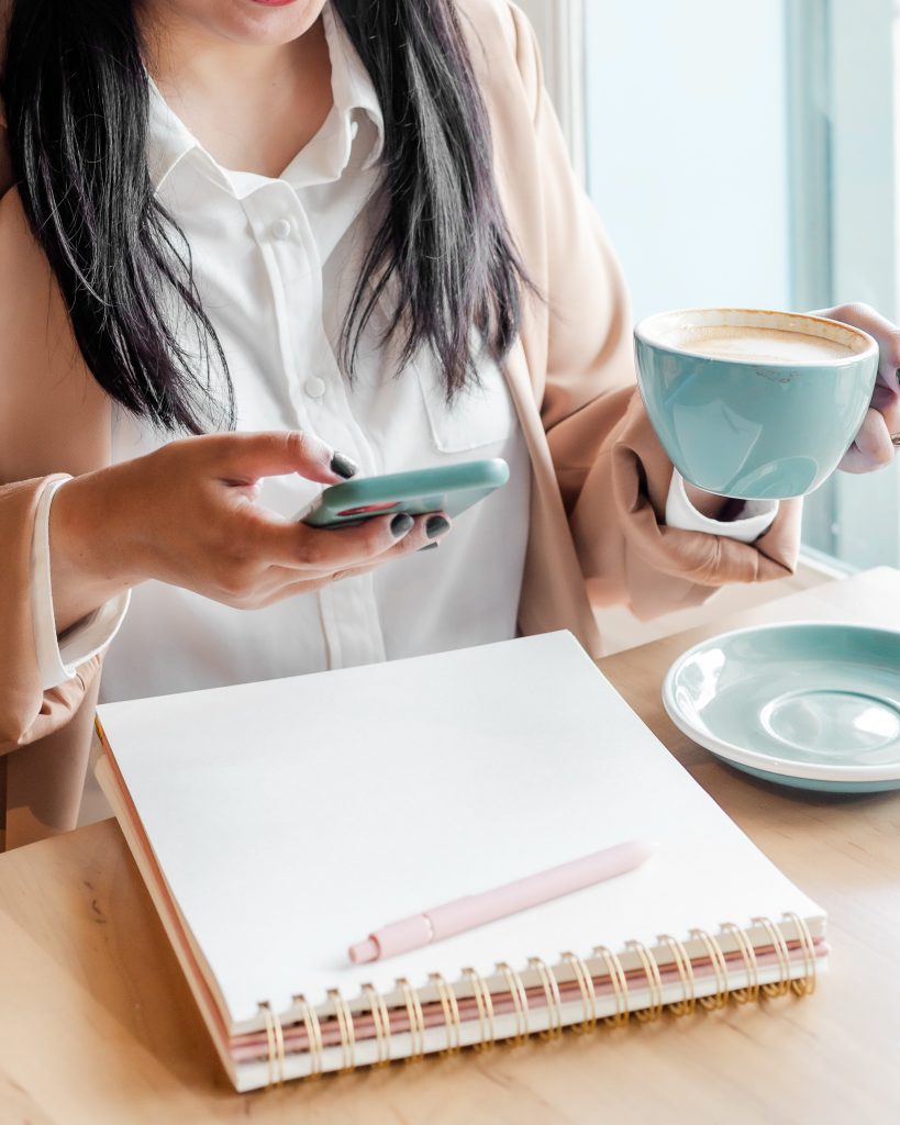 Business woman holding phone and coffee